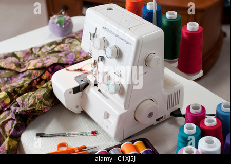 Serger on table sewing fabric Stock Photo