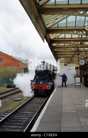 LMS Stanier 8F 2-8-0 locomotive 8624 passing through great central railway loughborough station working a morning train Stock Photo