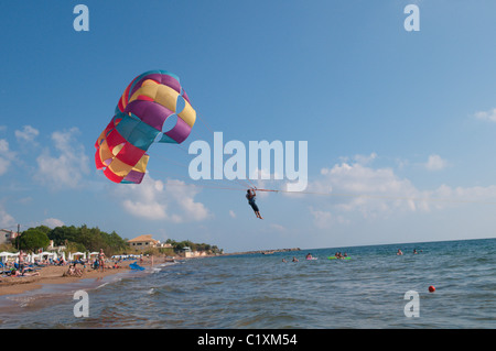 Corfu, Greece. October. View south along the beach at Agios Georgios, known as Saint George South. Watersport. Parascending. Stock Photo