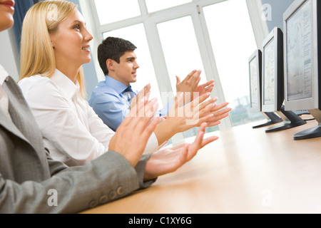 Row of happy business partners applauding at conference Stock Photo