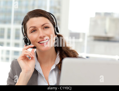Thoughtful businesswoman talking on the phone while working on her computer Stock Photo