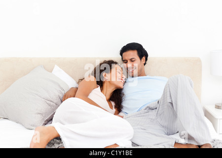 Lovely hispanic couple relaxing in their bedroom Stock Photo