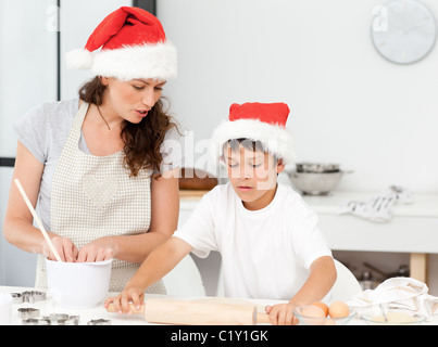 Mother and son preparing Christmas biscuits together Stock Photo