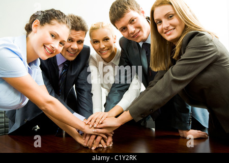 Portrait of happy business team keeping their hands on top of each other Stock Photo