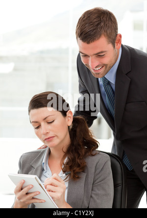 Serious businesswoman taking notes while discussing with her colleague Stock Photo