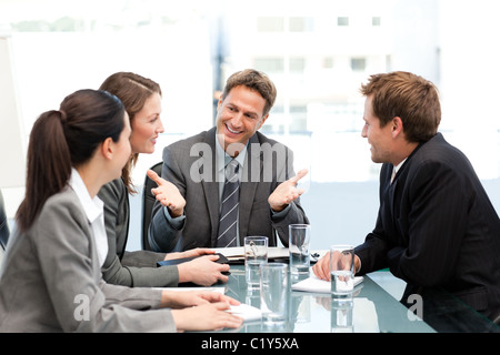 Delighted managertalking to his team at a table Stock Photo