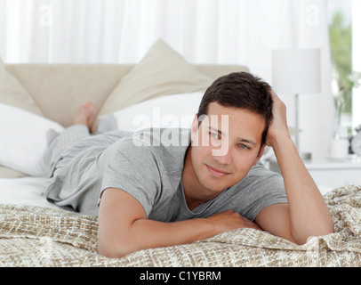 Thoughtful young man lying on his bed Stock Photo