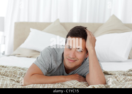 Portrait of a happy man relaxing on his bed Stock Photo