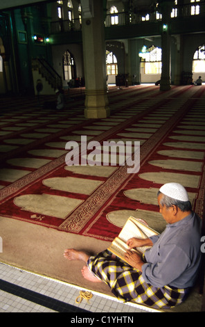 Singapore. Muslim follower reads Koran in Singapore Sultan mosque © Bob Kreisel Stock Photo