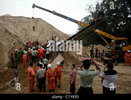 man has survived being buried under tons of sand in a sandyward in Wuhan, China. Rescuers took six hours to pull the injured Stock Photo