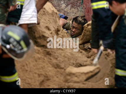 man has survived being buried under tons of sand in a sandyward in Wuhan, China. Rescuers took six hours to pull the injured Stock Photo