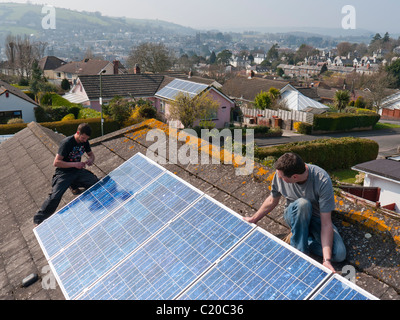 Photovoltaic solar panels being fitted to a roof in Totnes Devon UK Stock Photo