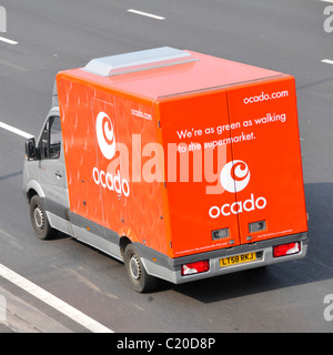 Side back rear & roof aerial view from above looking down on red Ocado online grocery food shopping delivery van & logo driving on English UK motorway Stock Photo