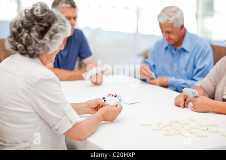 Retired people playing cards together Stock Photo