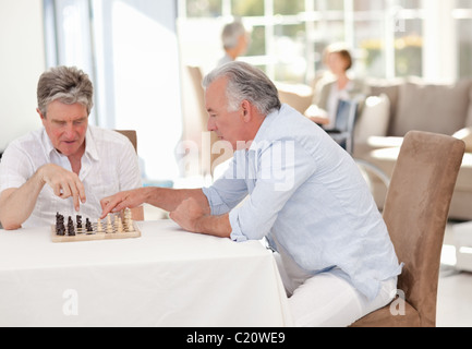 Seniors playing chess in the living room Stock Photo
