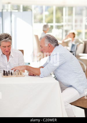 Seniors playing chess in the living room Stock Photo