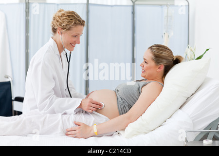 Nurse reassuring her pregnant patient Stock Photo