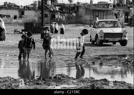 Jabalya Refugee Camp, Gaza 1988. Children crossing overflowing raw sewage. Stock Photo