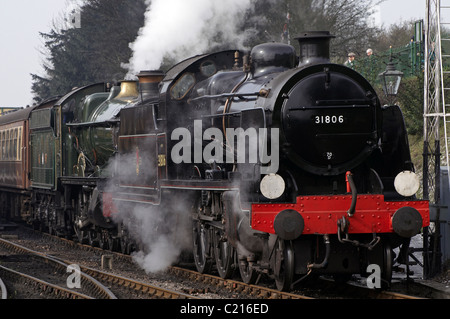Steam engines double heading a train on the Mid-Hants Railway,  - GWR Pitchford Hall behind U-class. Stock Photo