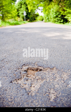 Road with holes in spring. Damaged by cold in winter Stock Photo