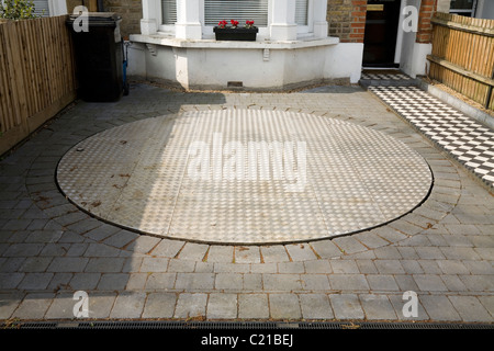 Rotating turntable platform to spin parked car for easy access to domestic driveway. Stock Photo