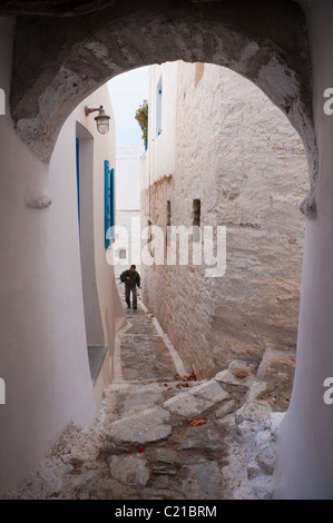 Man climbing a sloping alley in the village of Chora, on the Greek Cyclade island of Amorgos. Stock Photo