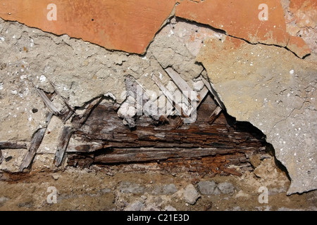 Fragment of an old wall of orange colour with the fallen off plaster Stock Photo