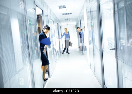 Office corridor and people looking out from the rooms Stock Photo