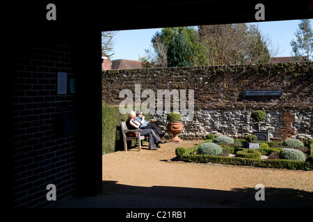 two people sat on bench in Physic Garden Petersfield Stock Photo