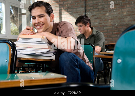 students, looking, at, the, camera, at, university, classroom, campus smiling, between, books, studying, hard, work, homework. Stock Photo