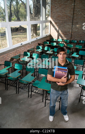 student, at, classroom, holding, books, stand, up, looking, at, the, camera, at, university, campus. Stock Photo