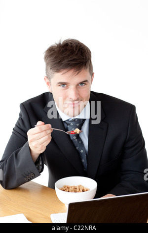 Charming businessman using a laptop while having breakfast Stock Photo