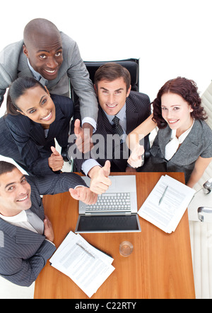 Smiling business team doing a thumb-up Stock Photo