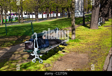 Homeless man sleeping on a park bench; Paris, France, Europe. Charles Lupica Stock Photo