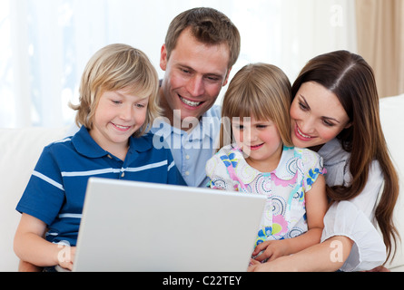 Smiling family using a laptop Stock Photo