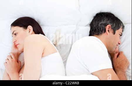 Upset couple sleeping in their bed separately Stock Photo