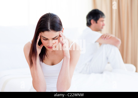 Sad couple having an argument sitting on bed Stock Photo