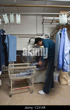 Man loading clothes into the washing machine Stock Photo
