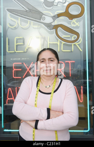 Woman standing infront of laundrette shop window Stock Photo
