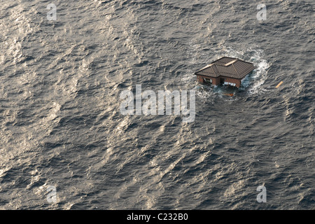 Aerial photo taken March 13 2011 of a house floating at sea near Sendai, Japan, in the aftermath of the earthquake + tsunami. Stock Photo