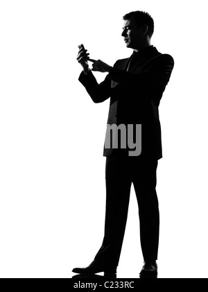 silhouette caucasian business man on the phone sms text messaging full length on studio isolated white background Stock Photo