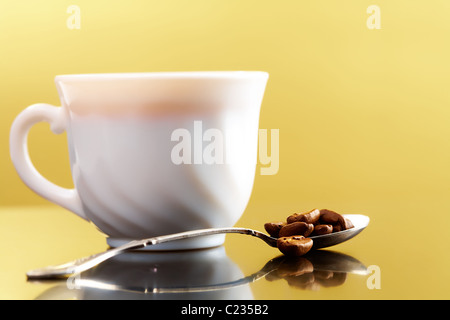 Photo of porcelain coffee cup with spoon full of coffee beans near by Stock Photo