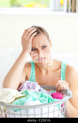 Depressed young woman doing the laundry Stock Photo