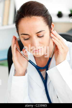 Concentrated doctor using a stethoscope Stock Photo