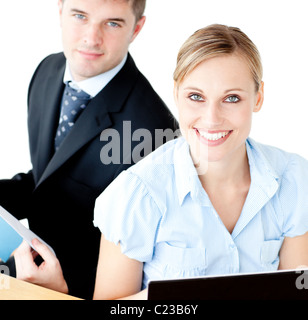 Beautiful couple of businesspeople smiling at camera using laptop Stock Photo