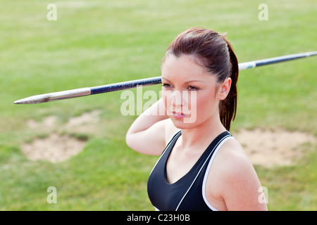 Determined female athlete ready to throw javelin Stock Photo