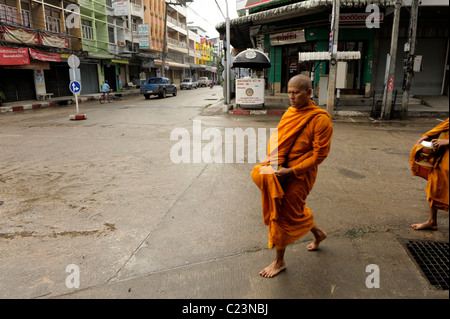 monks and novice on their daily alms round , mae sot town, early morning , northern thailand Stock Photo