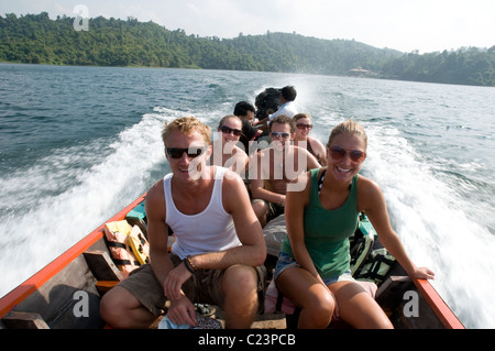 Tourists in a Thai long-boat, Cheow Larn Lake, Khao Sok National Park, Southern Thailand Stock Photo