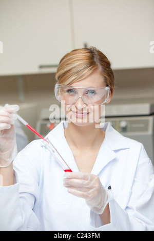Close-up of a female scientist putting liquid in a test tube with a pipette Stock Photo