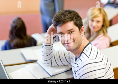 Joyful male student smiling at the camera during an university lesson Stock Photo